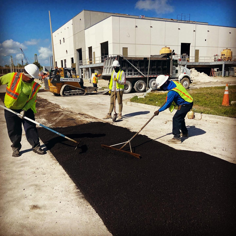 men stirring asphalt